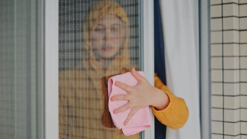 Portrait einer Fenster putzenden Frau.