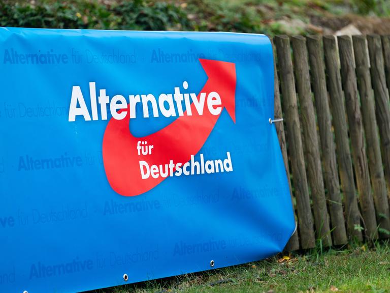 Ein Plakat mit dem Logo der Partei Alternative für Deutschland (AfD) hängt an einem Zaun.