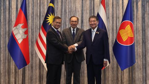 Hun Manet (l.) und Phumtham Wechayachai reichen sich die Hände. Anwar Ibrahim steht zwischen ihnen und legt seine Hände auf ihre.