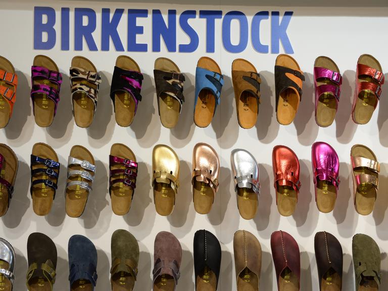 Schuhe von Birkenstock hängen an einer Wand zur Präsentation