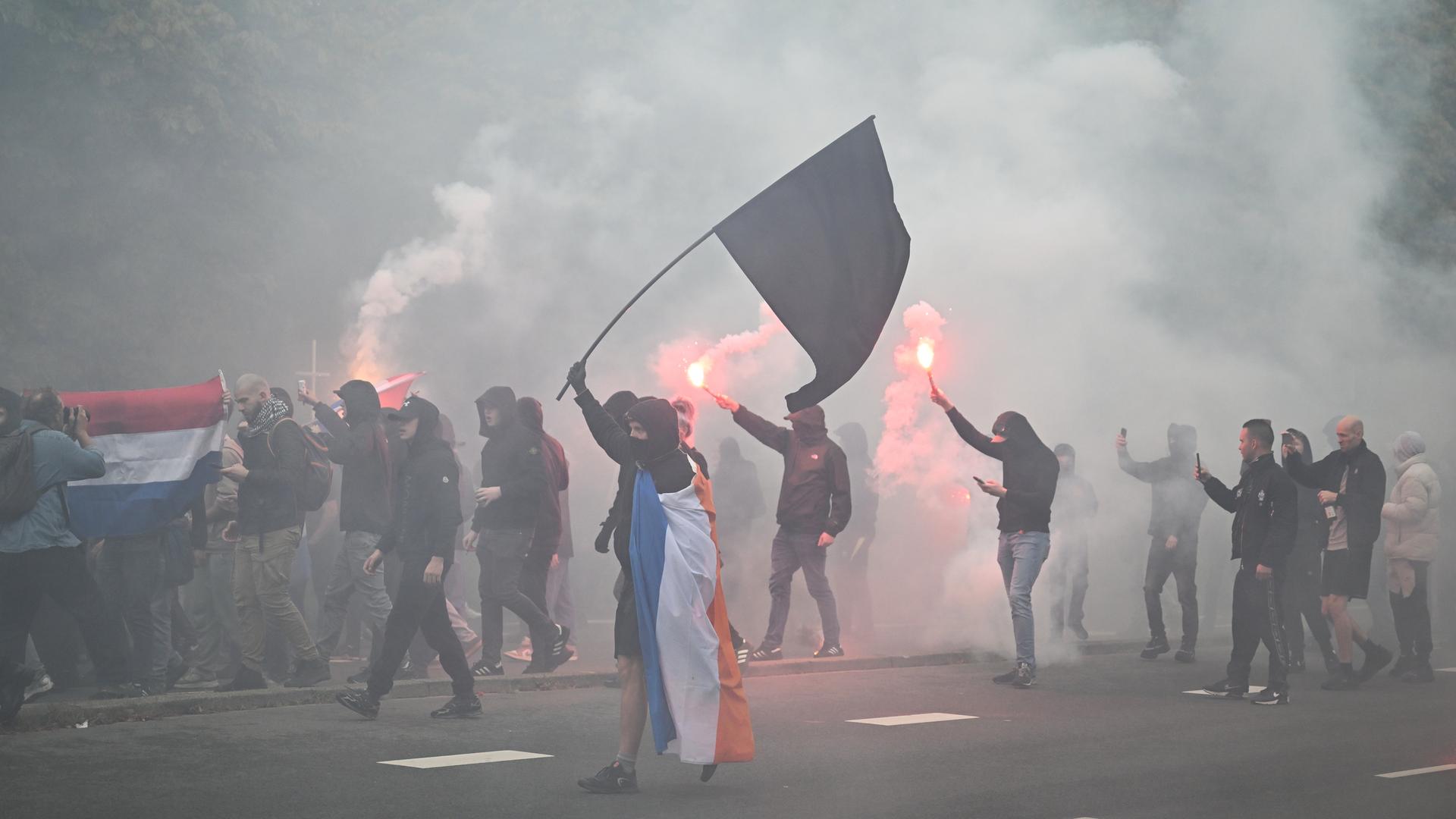 Demonstration rechtsextremer Gruppen in Den Haag. Einige Teilnehmer sind vermummt.