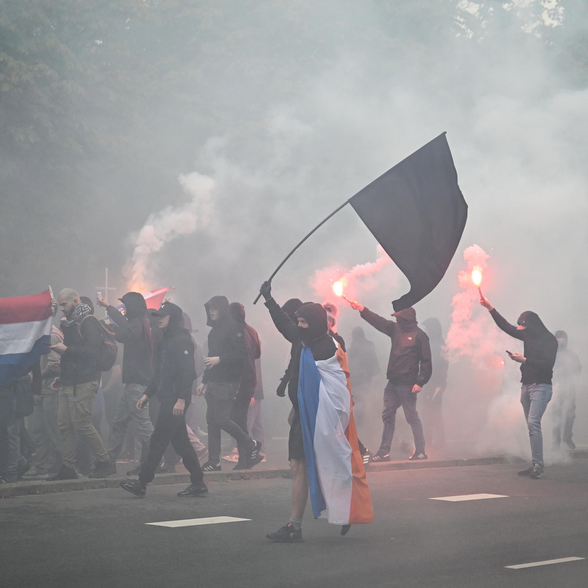 Demonstration rechtsextremer Gruppen in Den Haag. Einige Teilnehmer sind vermummt.