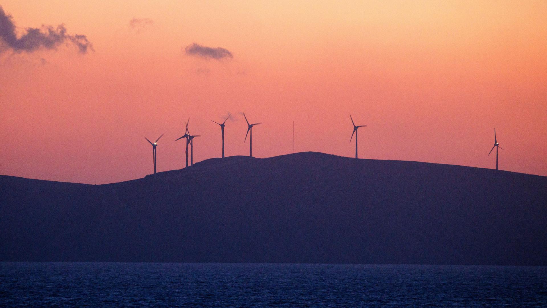 Ein Windpark auf der Insel Rhodos ist im Licht des Sonnenaufgangs zu sehen