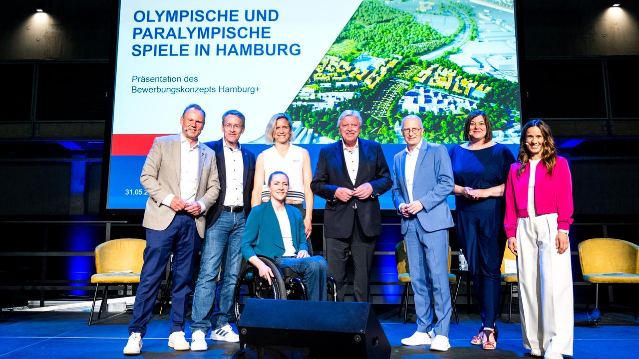 Zahlreiche Personen stehen bei der Vorstellung des Konzepts von Hamburgs Olympia-Bewerbung zusammen auf der Bühne. 