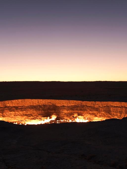 Ein Feuerkrater inmitten einer nächhtlich-dunklen Landschaft.