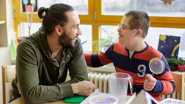 Ein Bundesfreiwilligendienstleistender zusammen mit einem Schüler in der Marianne-Cohn-Schule in Berlin.
