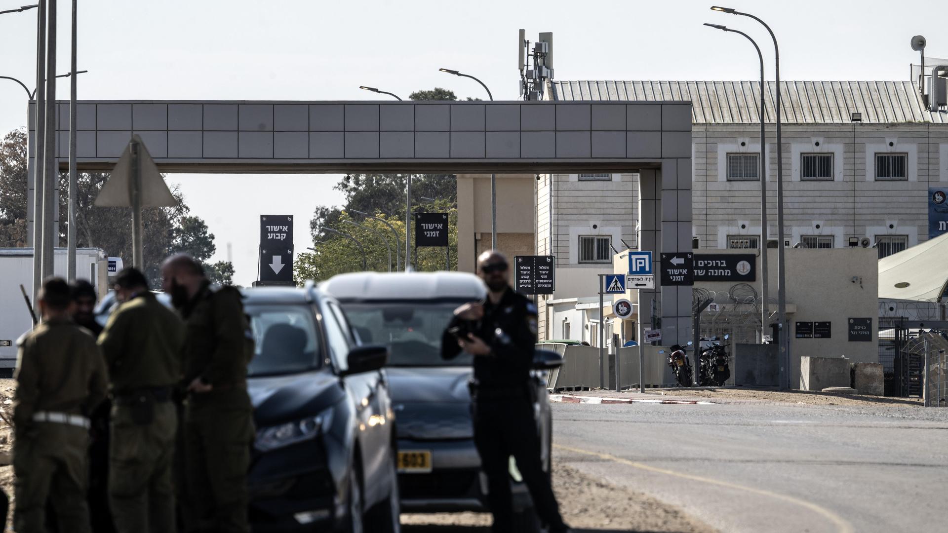 Blick auf den Militärstützpunkt Sde Teiman, nahe dem Gazastreifen. Im Vordergrund bewaffnete israelische Soldaten, im Hintergrund der Gebäudekomplex. Blick auf den Militärstützpunkt Sde Teiman, nahe dem Gazastreifen. Im Vordergrund bewaffnete israelische Soldaten, im Hintergrund der Gebäudekomplex.