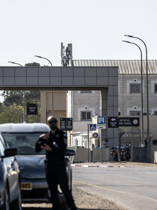 Blick auf den Militärstützpunkt Sde Teiman, nahe dem Gazastreifen. Im Vordergrund bewaffnete israelische Soldaten, im Hintergrund der Gebäudekomplex.
