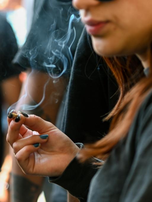 Eine junge Frau raucht einen Joint.