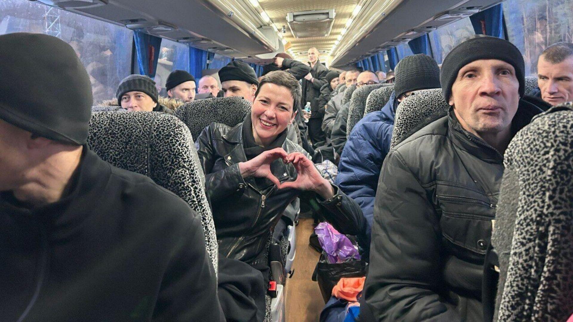 Die belarussische Oppositionspolitikerin Maria Kolesnikowa nach ihrer Freilassung aus fünfjähriger Haft zeigt ein Herz. Sie sitzt im Bus zwischen vielen anderen früheren MItgefangenen. Die belarussische Oppositionspolitikerin Maria Kolesnikowa nach ihrer Freilassung aus fünfjähriger Haft zeigt ein Herz. Sie sitzt im Bus zwischen vielen anderen früheren MItgefangenen.