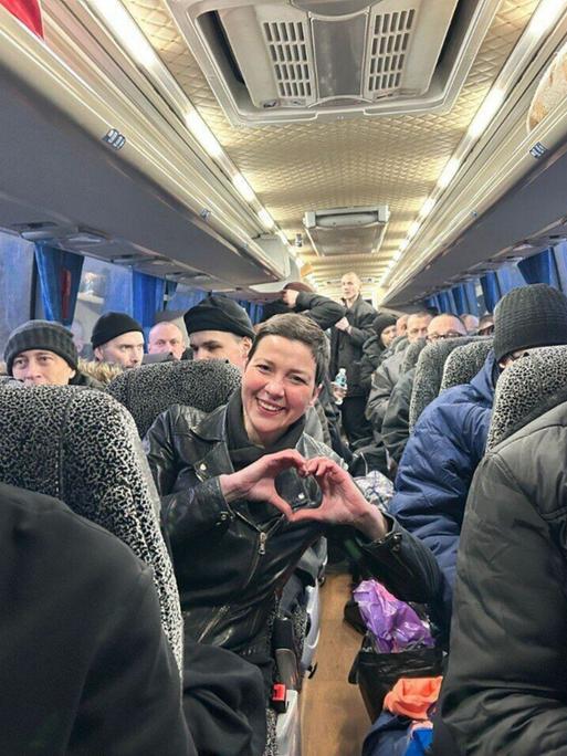 Die belarussische Oppositionspolitikerin Maria Kolesnikowa nach ihrer Freilassung aus fünfjähriger Haft zeigt ein Herz. Sie sitzt im Bus zwischen vielen anderen früheren MItgefangenen. Die belarussische Oppositionspolitikerin Maria Kolesnikowa nach ihrer Freilassung aus fünfjähriger Haft zeigt ein Herz. Sie sitzt im Bus zwischen vielen anderen früheren MItgefangenen.