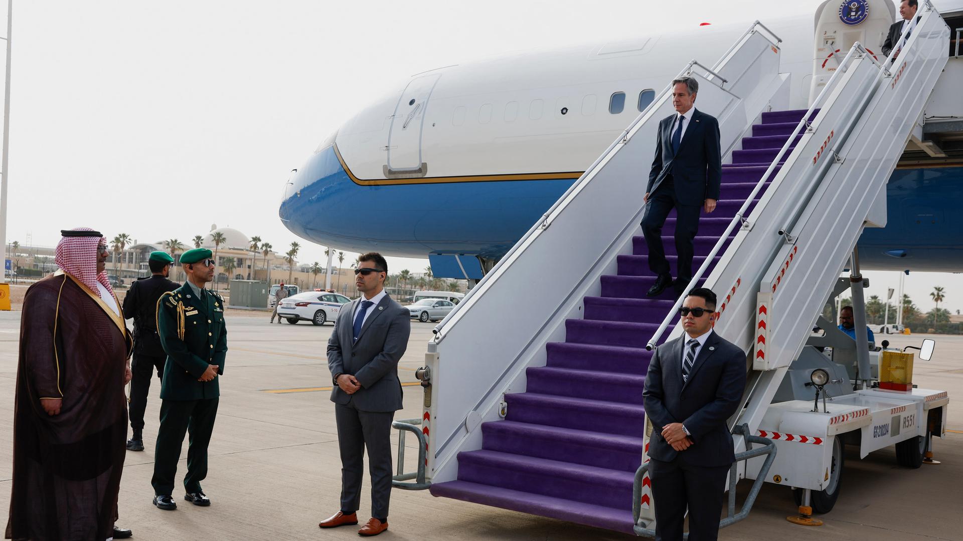 US-Außenminister Antony Blinken kommt in Riad, Saudi-Arabien, an: Er steigt eine Flugzeugtreppe hinab, unten stehen mehrere Menschen.