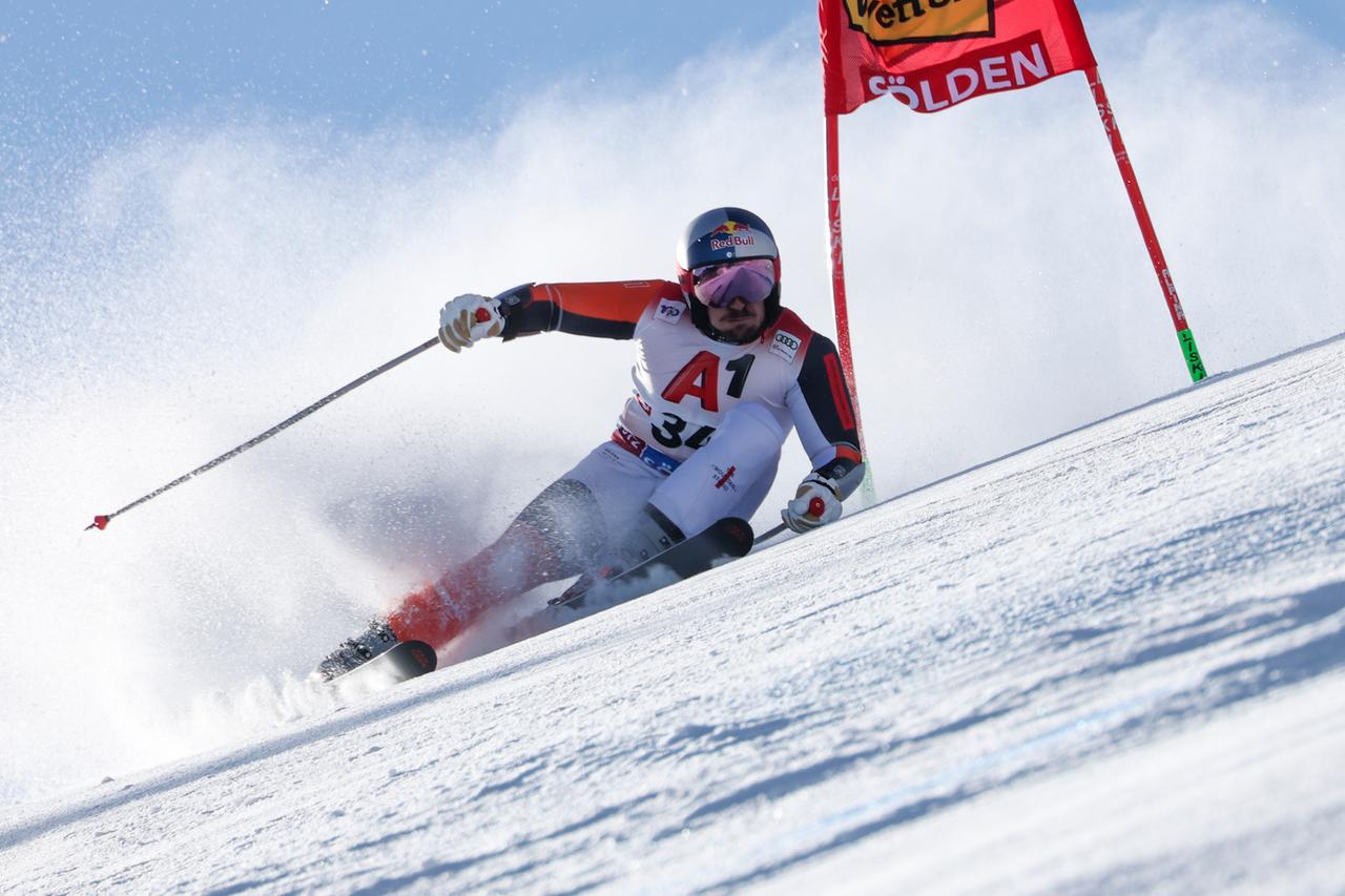 Marcel Hirscher fährt mit starker Schräglage eng an einem Tor vorbei und bläst dabei die Backen auf.