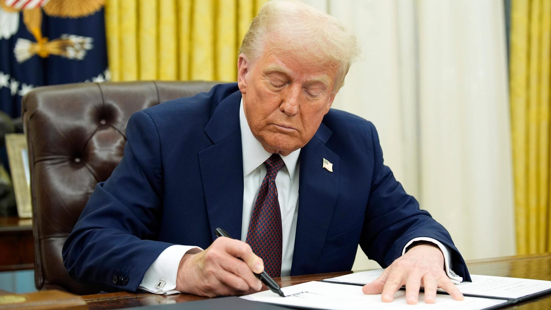 Das Foto zeigt Donald Trump an seinem Schreib-Tisch in seinem Büro. 