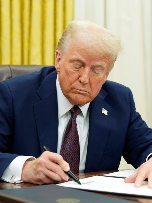 Das Foto zeigt Donald Trump an seinem Schreib-Tisch in seinem Büro. 