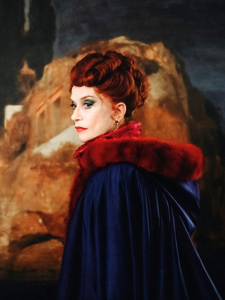 Isabelle Huppert als Aristokratin des 19. Jahrhunderts mit knallrot gefärbten Haaren und sehr viel Schminke im Gesicht