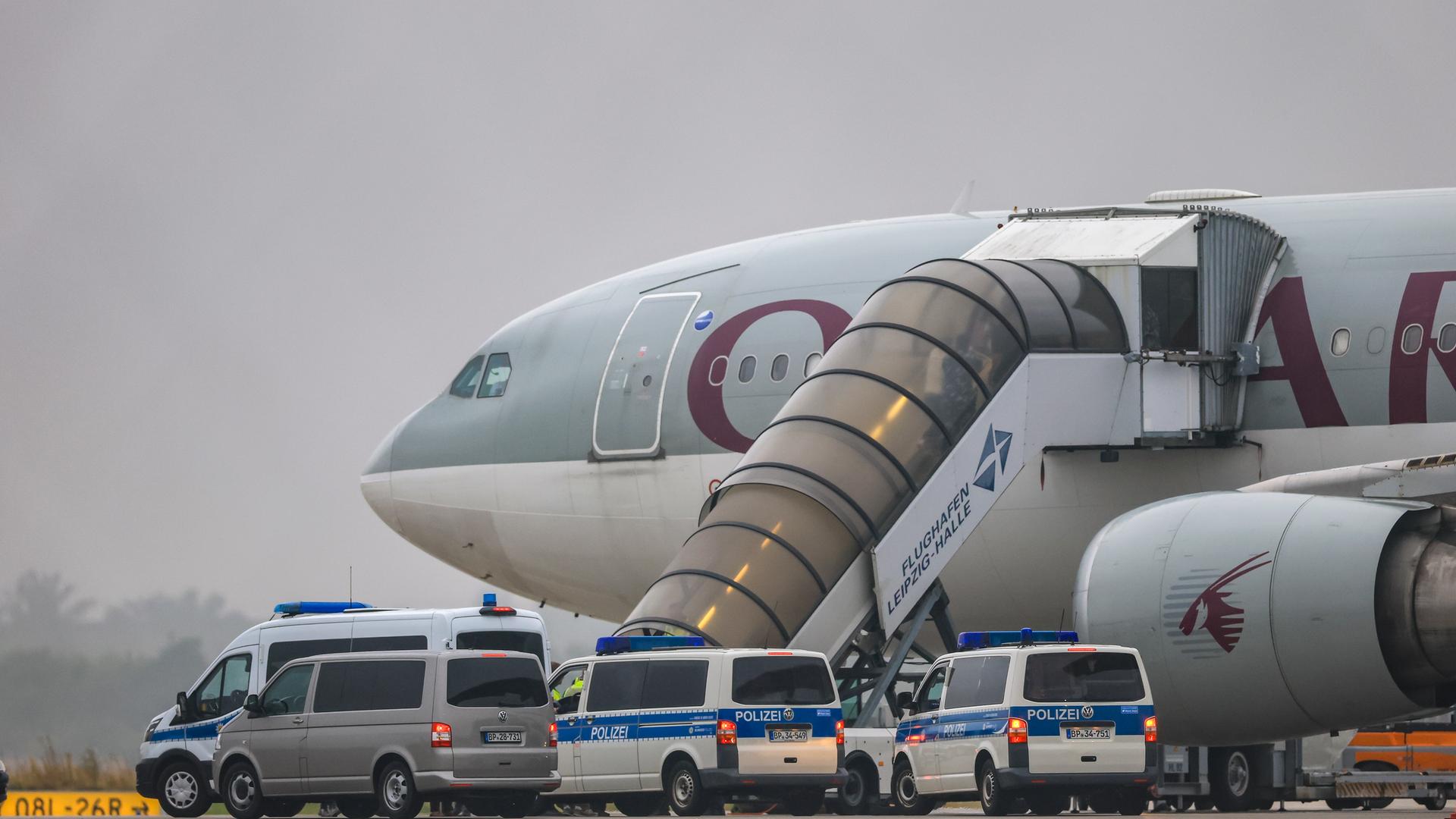 Ein Flugzeug der Qatar Airways, vor dem Fahrzeuge der Bundespolizei stehen, steht auf dem Vorfeld am Flughafen Leipzig/Halle. Ein Flugzeug der Qatar Airways, vor dem Fahrzeuge der Bundespolizei stehen, steht auf dem Vorfeld am Flughafen Leipzig/Halle.