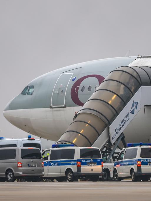 Ein Flugzeug der Qatar Airways, vor dem Fahrzeuge der Bundespolizei stehen, steht auf dem Vorfeld am Flughafen Leipzig/Halle. Ein Flugzeug der Qatar Airways, vor dem Fahrzeuge der Bundespolizei stehen, steht auf dem Vorfeld am Flughafen Leipzig/Halle.