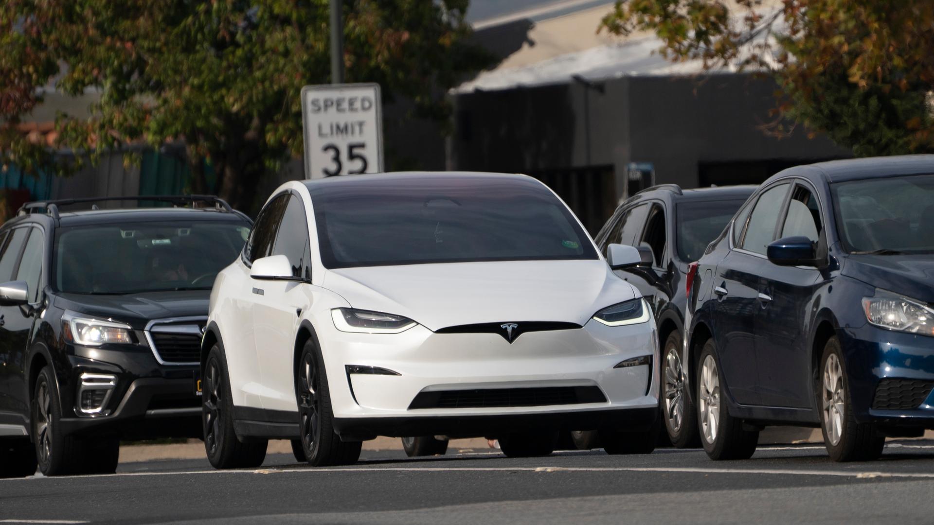 Das weißes Elektroauto fährt inmitten anderer Fahrzeuge auf einer Straße in den USA.