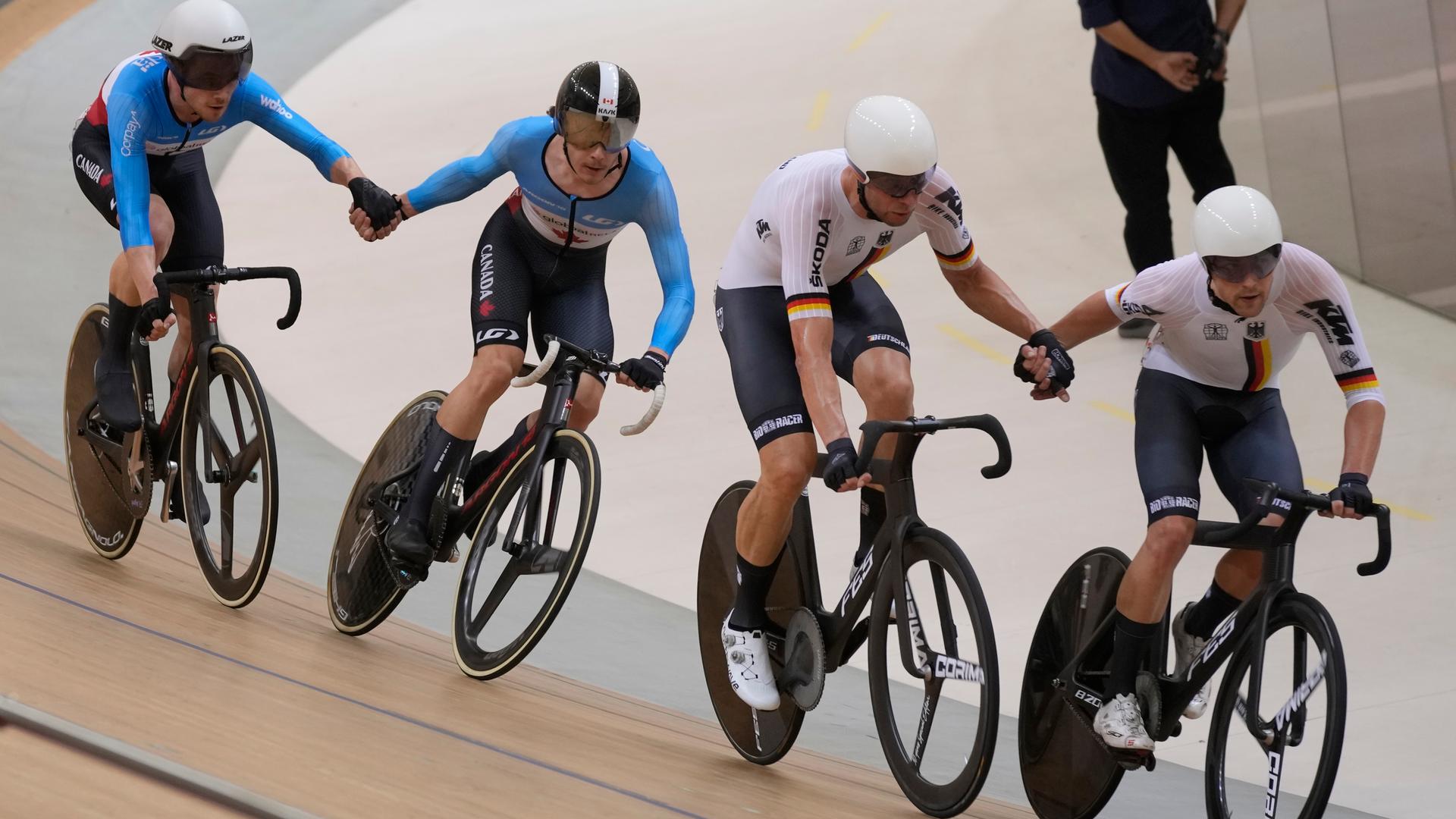 Das Foto zeigt Bahnrad-Sportler. Zu sehen sind die Kanadier Michael Foley und Mathias Guillemette, links, und die Deutschen Roger Kluge und Theo Reinhardt während eines Madison-Rennens im Jakarta International Velodrome in Indonesien.