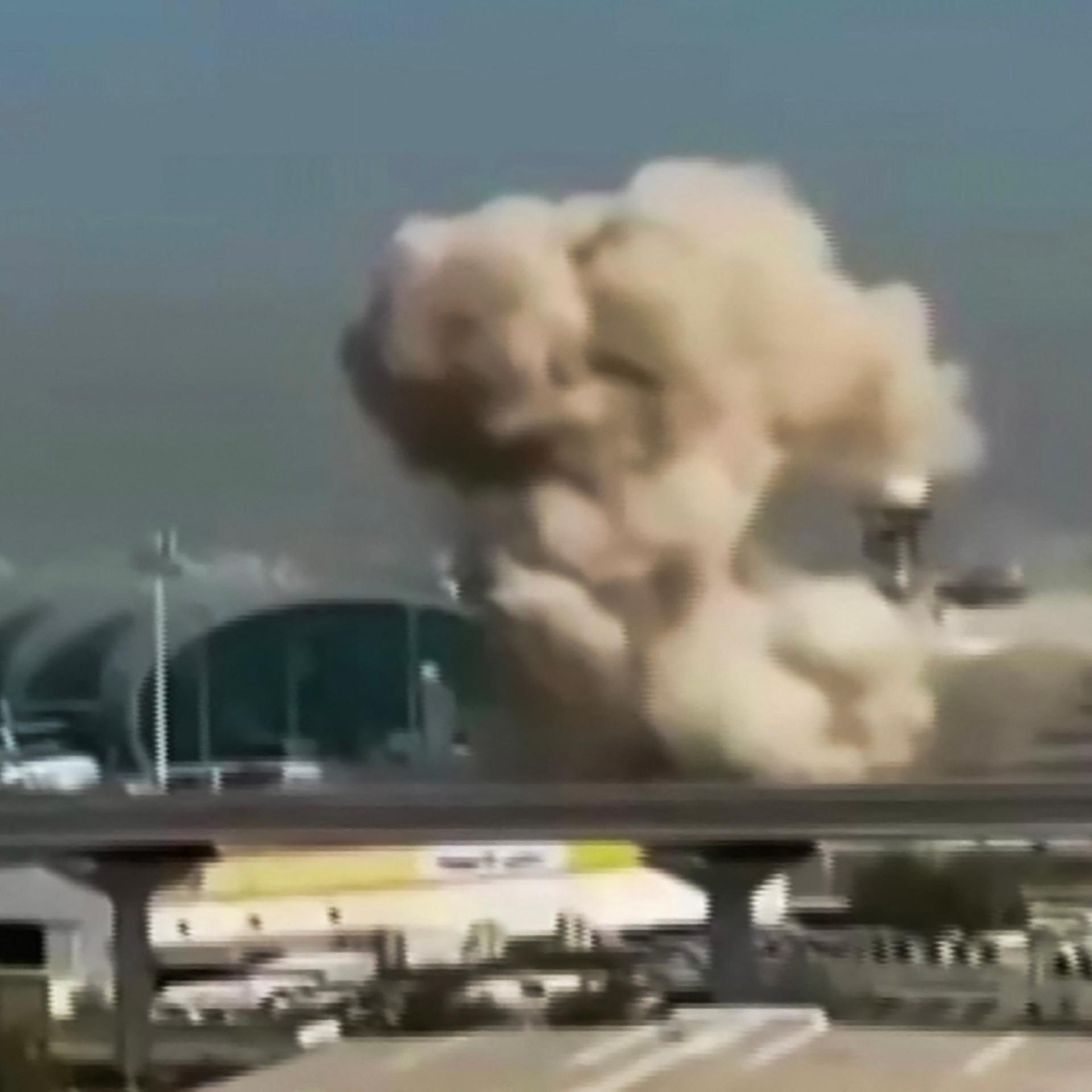 Das etwas unscharfe Foto zeigt Rauch, der über dem internationalen Flughafen von Dubai aufsteigt.