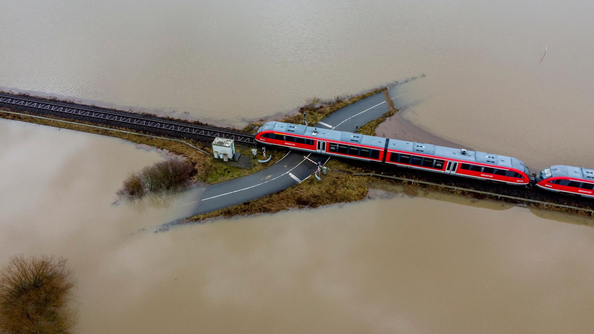 Luftaufnahme auf einen Zug umgeben von Hochwasser