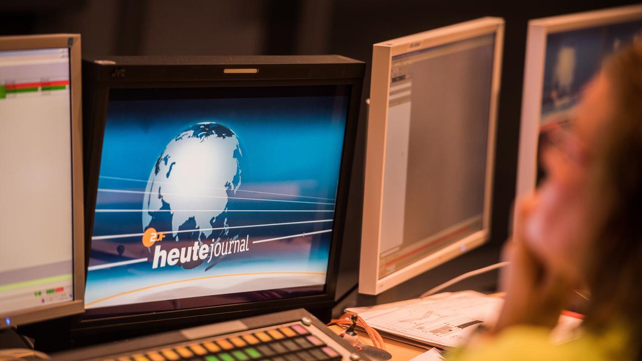 Auf einem Bildschirm ist das Logo des "heute journal" zu sehen, eine Weltkugel vor blauem Grund.