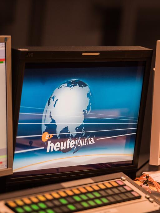Auf einem Bildschirm ist das Logo des "heute journal" zu sehen, eine Weltkugel vor blauem Grund.