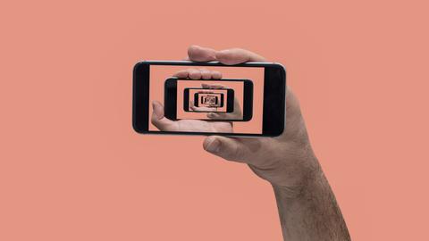 Collage einer Hand, die ein Smartphone hält. Auf dem Bildschirm sind immer weitere Smartphones im Smartphone zu sehen.