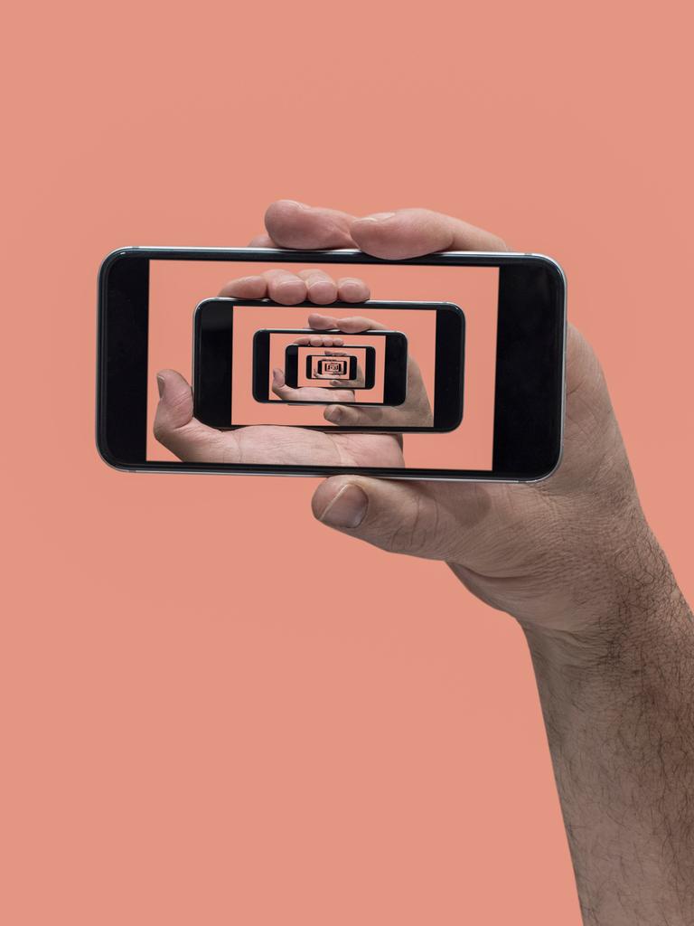 Collage einer Hand, die ein Smartphone hält. Auf dem Bildschirm sind immer weitere Smartphones im Smartphone zu sehen.