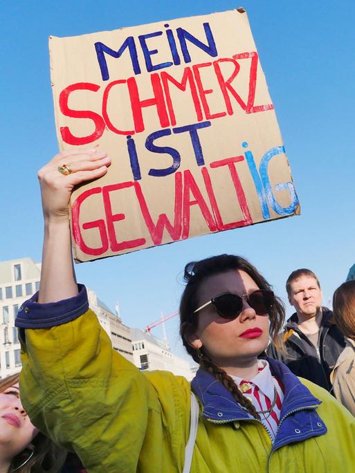 Demo Gegen sexualisierte digitale Gewalt am Brandenburger Tor in Berlin - eine Frau hält ein Schild mit der Aufschrift: Mein Schmerz ist gewaltig