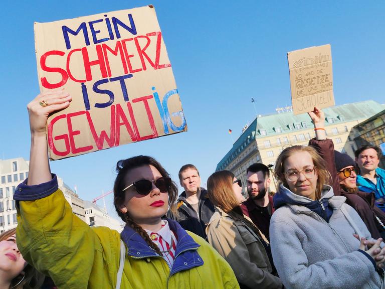 Demo Gegen sexualisierte digitale Gewalt am Brandenburger Tor in Berlin - eine Frau hält ein Schild mit der Aufschrift: Mein Schmerz ist gewaltig