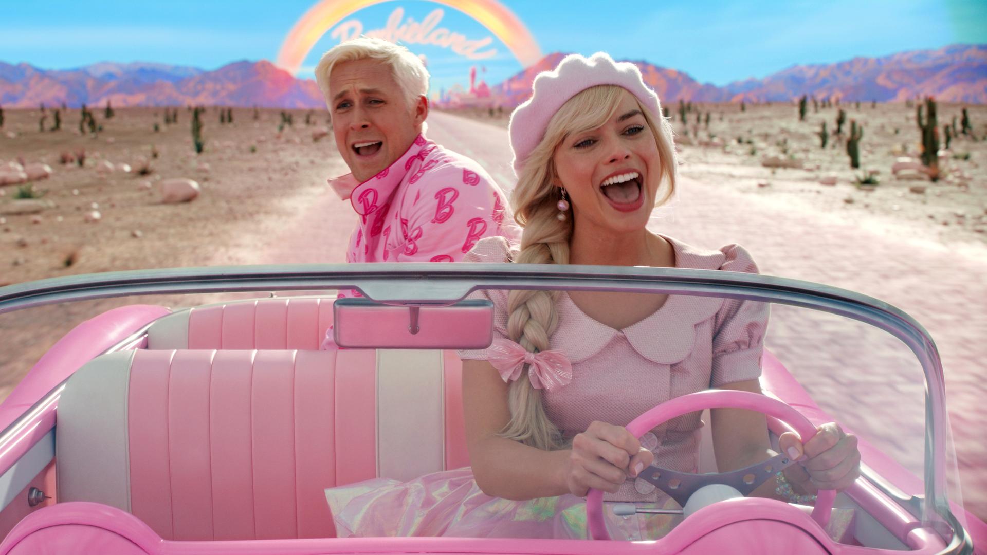 Szene aus dem Film Barbie, in dem Barbie und Ken in einem pinken Cabrio fahren.