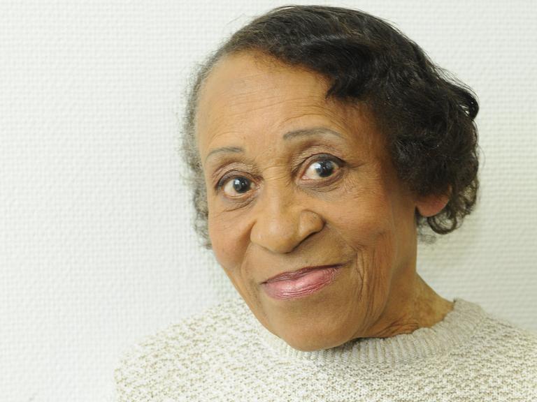Portrait von Marie Nejar, die einen hellen Pullover trägt und freundlich in die Kamera lächelt