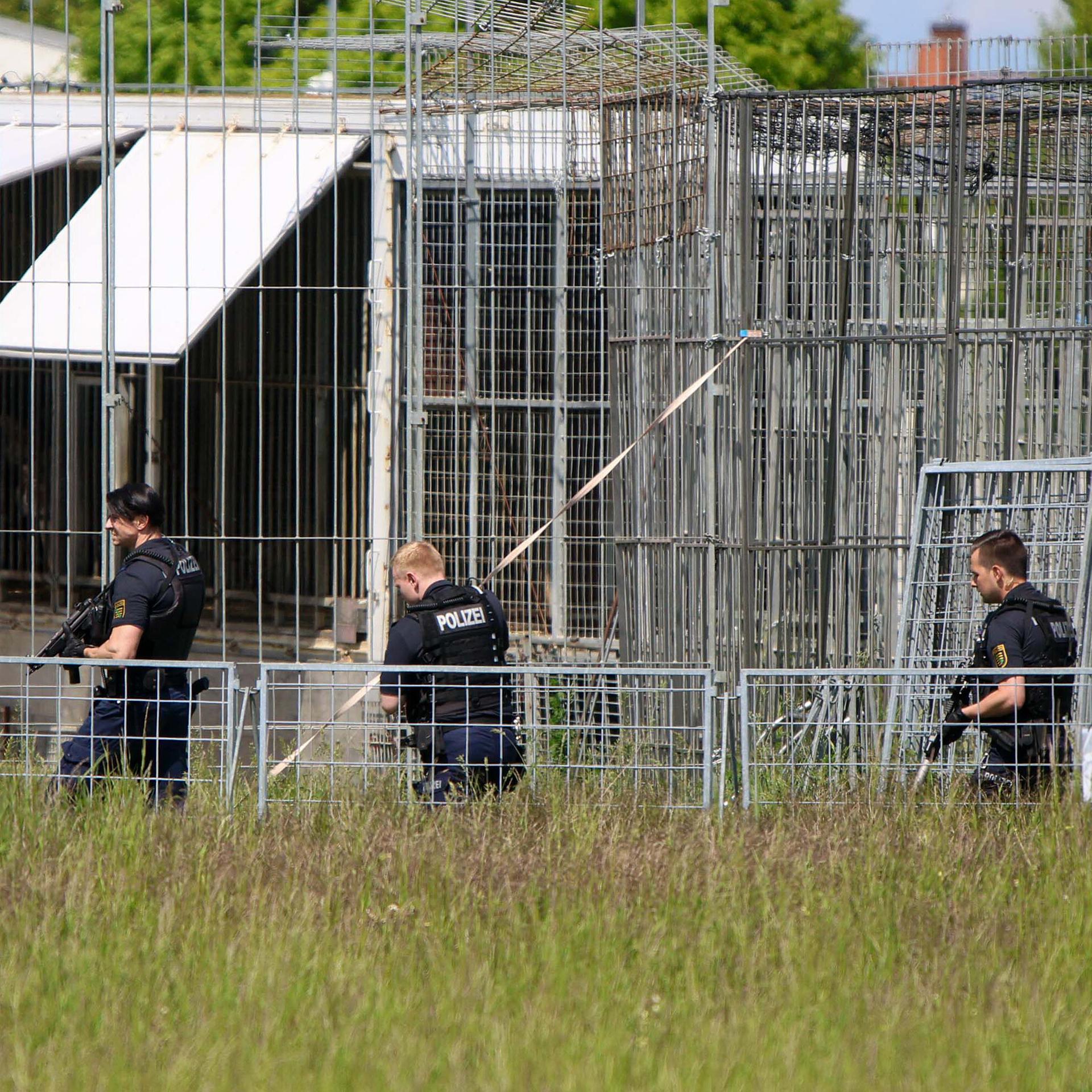 Schwer bewaffnete Polizisten sind in einem Gewerbegebiet an einer Käfig-Anlage für Raubkatzen im Einsatz. Die Polizei hat am Nachmittag bei Leipzig einen entlaufenen Tiger erschossen. Das Tier war aus einer privaten Anlage entkommen, wie eine Polizeisprecherin sagte. Ein Mann sei leicht verletzt worden.