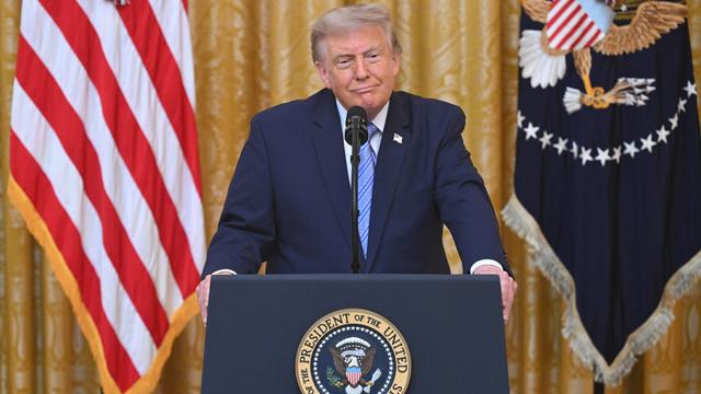 Donald Trump steht an einem Rednerpult.