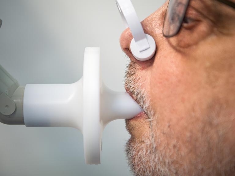 Reinhard Janzen sitzt zur Überprüfung seiner Lungenfunktion in einem Bodyplethysmographen. In der Klinik am Teutoburger Wald werden Long-Covid-Patienten behandelt.