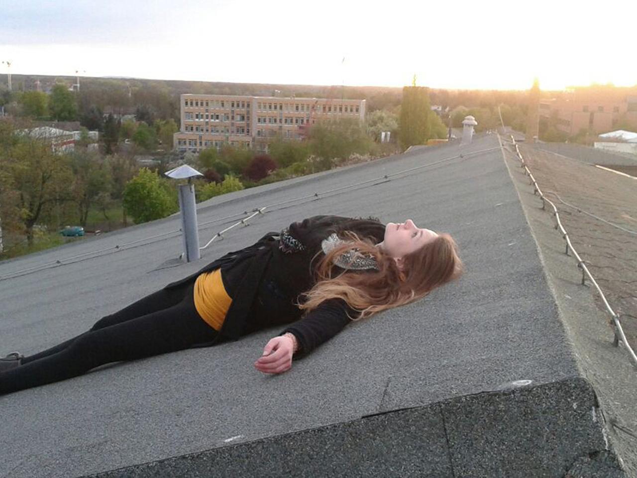 Eine junge Frau liegt auf einem Dach in Leipzig. 