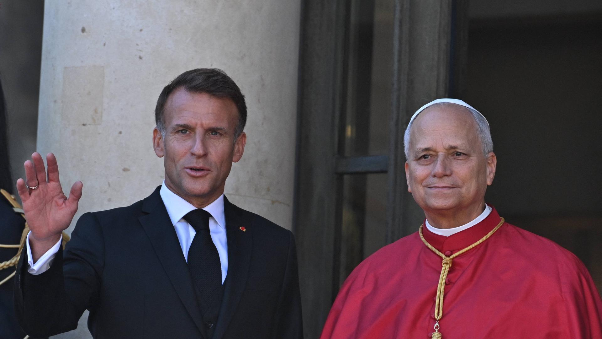Das Foto zeigt den französischen Präsidenten Macron in einem dunklen Anzug und Papst Franziskus 