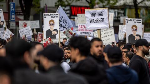 Teilnehmer einer Islamisten-Demo halten ein Plakat mit der Aufschrift "Mut zur Wahrheit" in die Höhe.