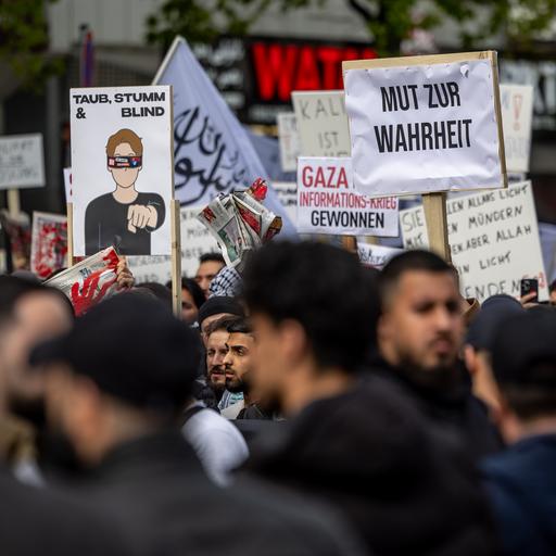 Teilnehmer einer Islamisten-Demo halten ein Plakat mit der Aufschrift "Mut zur Wahrheit" in die Höhe.