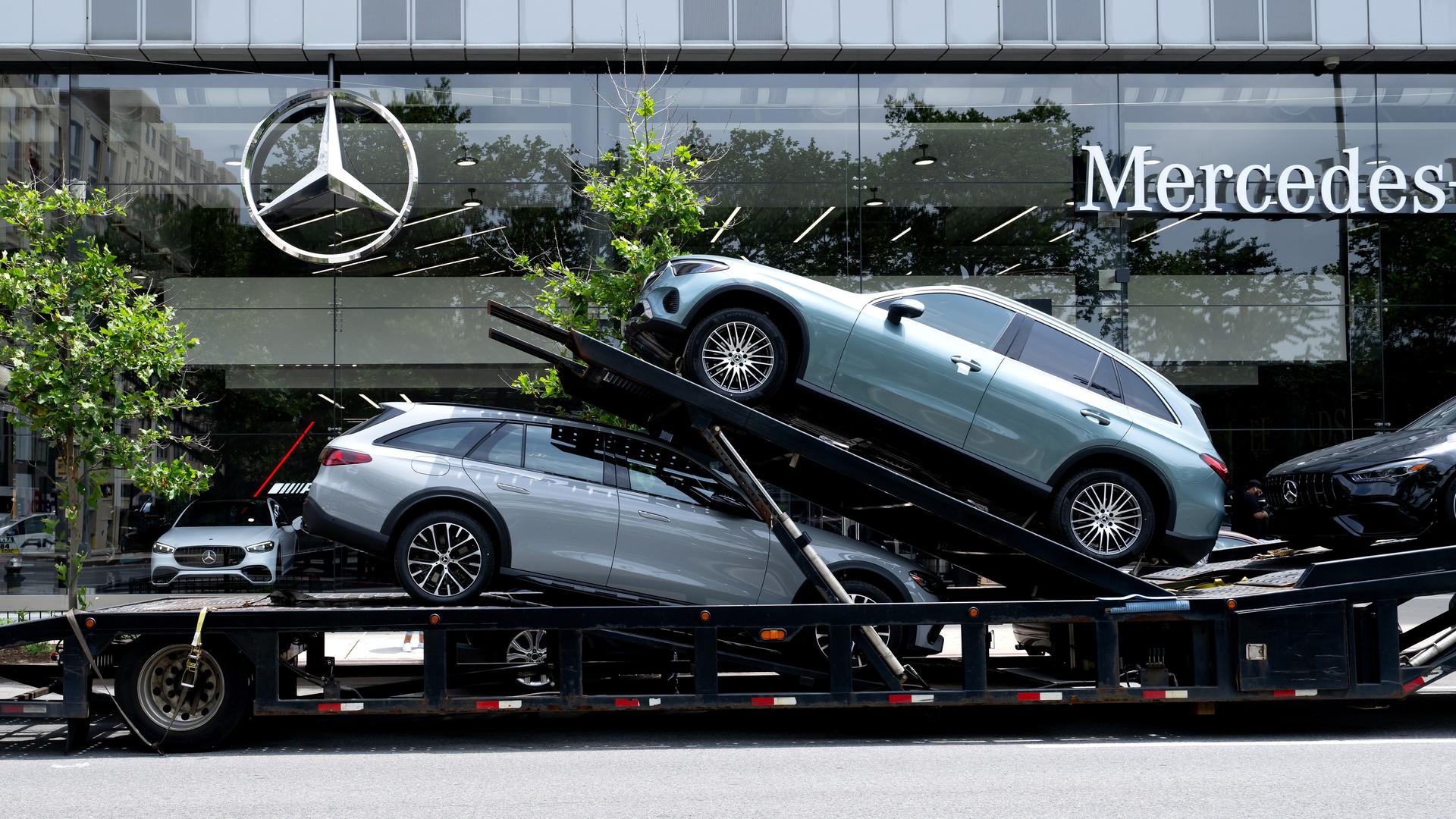 Ein Autotransporter mit Neuwagen von Mercedes-Benz steht vor einem Autohaus in Manhattan.