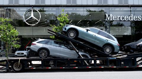 Ein Autotransporter mit Neuwagen von Mercedes-Benz vor einem Autohaus in New York