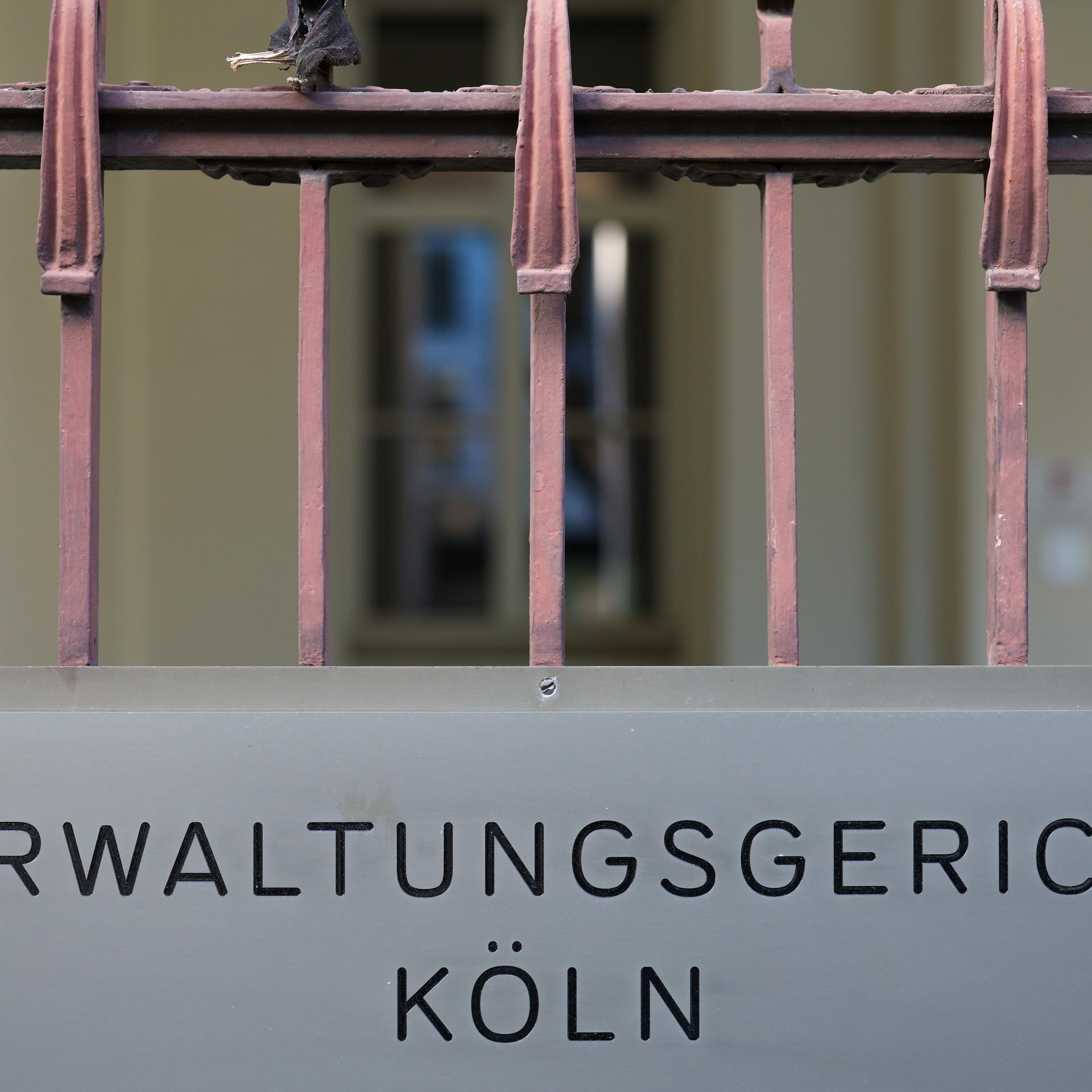 Ein Schild hängt am Eingang des Verwaltungsgerichts in Köln. Darauf steht: "Verwaltungsgericht Köln".