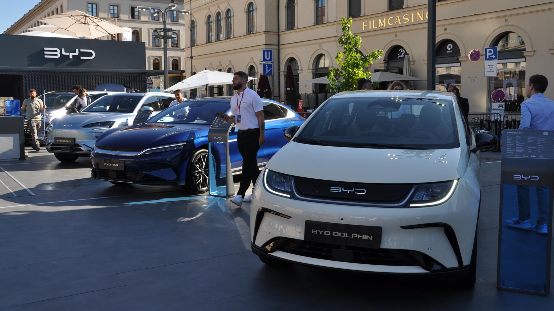 Mehrere Elektroautos stehen vor einer Halle auf der Münchener Automesse IAA.