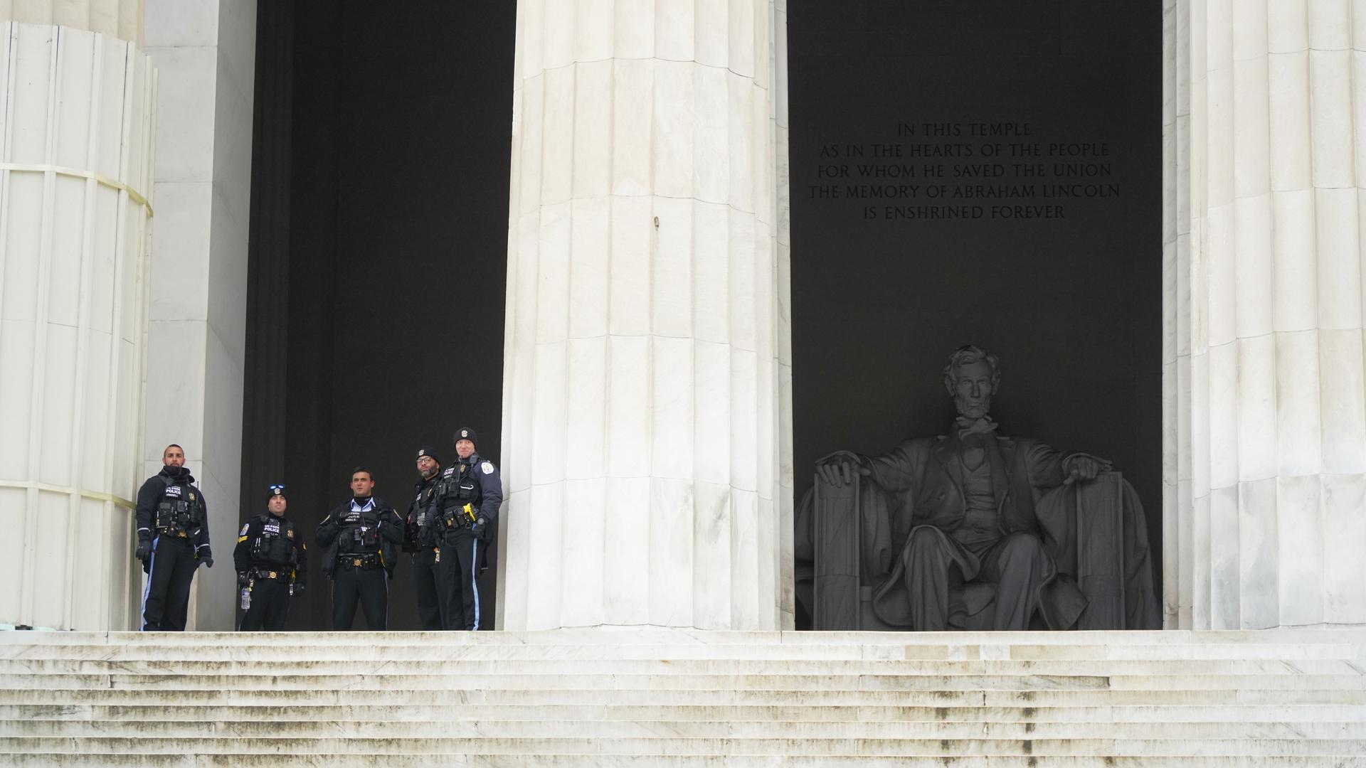 Vor einem großen Gebäude stehen US-Polizisten. Hinter ihnen ist ein Denkmal des ehemaligen US-Präsidenten Lincoln.