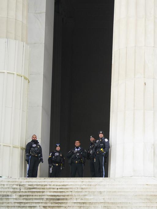 Vor einem großen Gebäude stehen US-Polizisten. Hinter ihnen ist ein Denkmal des ehemaligen US-Präsidenten Lincoln.