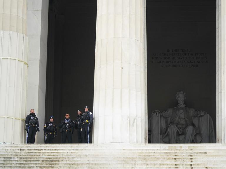 Vor einem großen Gebäude stehen US-Polizisten. Hinter ihnen ist ein Denkmal des ehemaligen US-Präsidenten Lincoln.