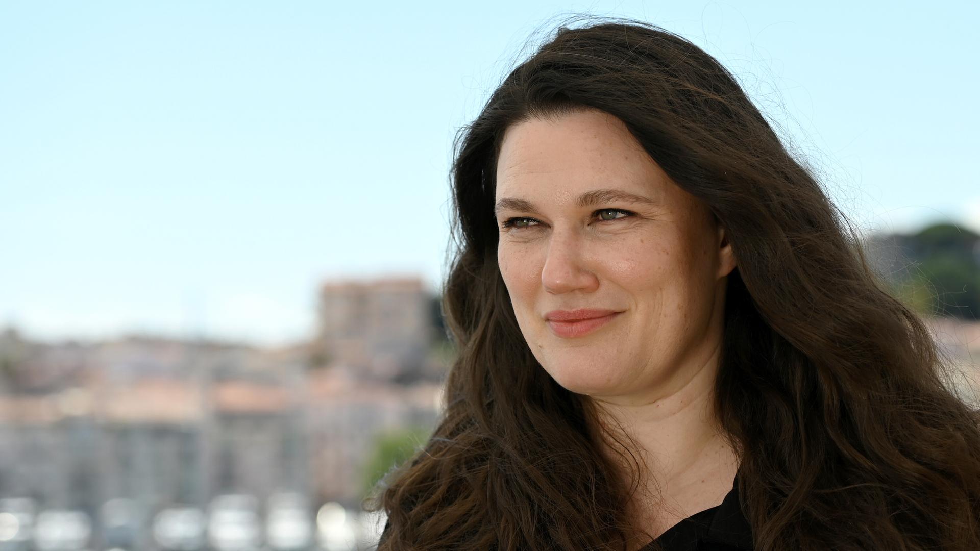 Mascha Schilinski, Deutsche Filmregisseurin und Drehbuchautorin, lächelt bei einem Pressetermin zu ihrem Film „In die Sonne schauen“ in die Kamera. 