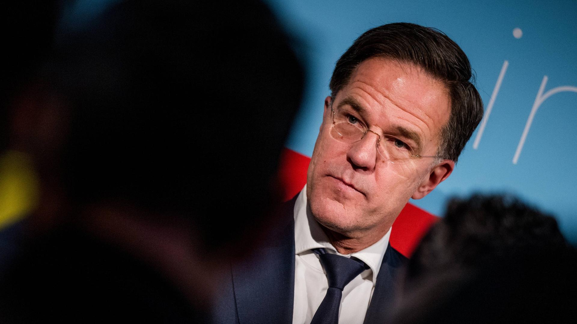 Nato-Generalsekretär Rutte, vor ihm, verschwommen, mehrere Personen.